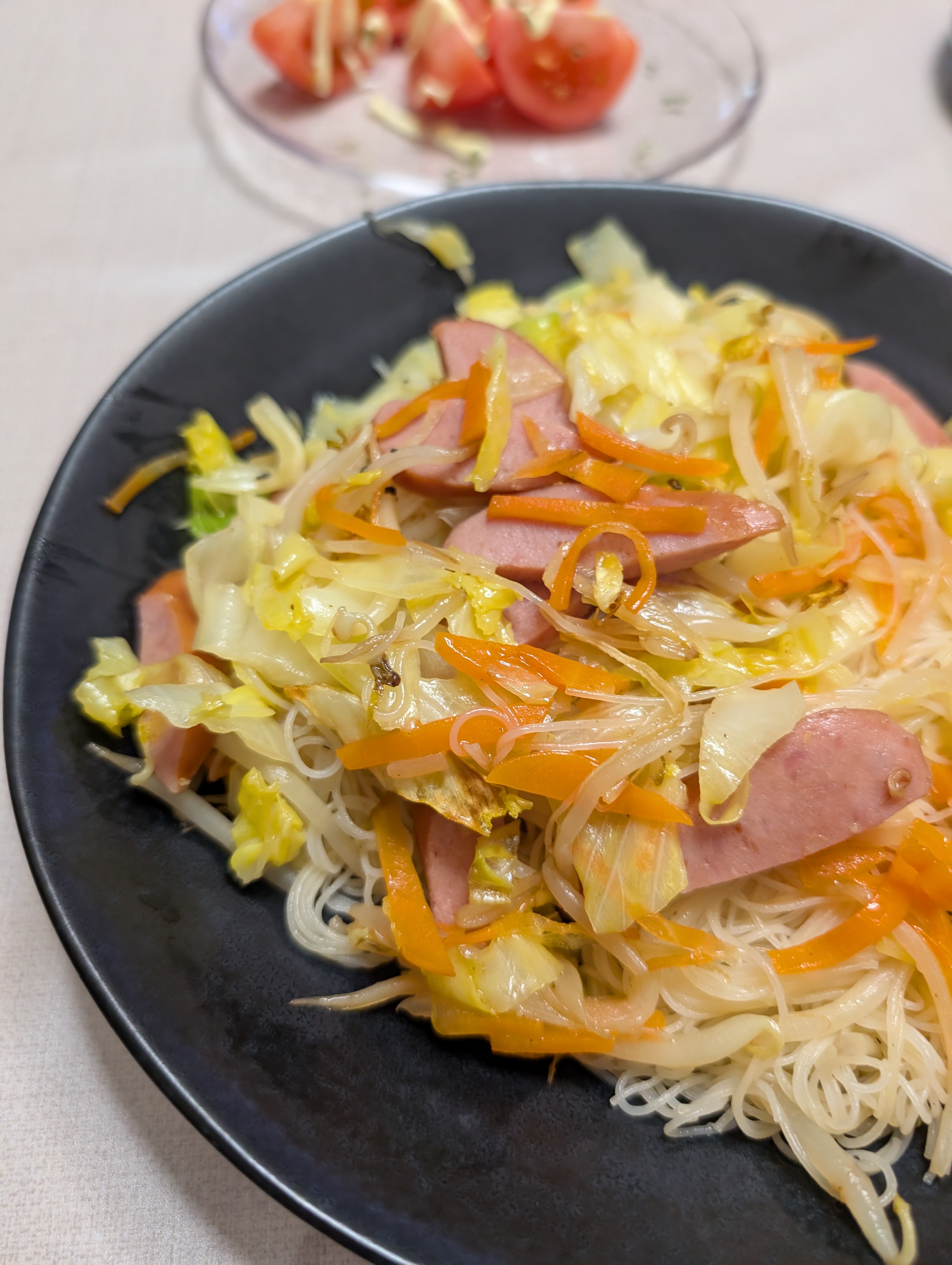 夕食。焼きビーフンにトマトを添えて。