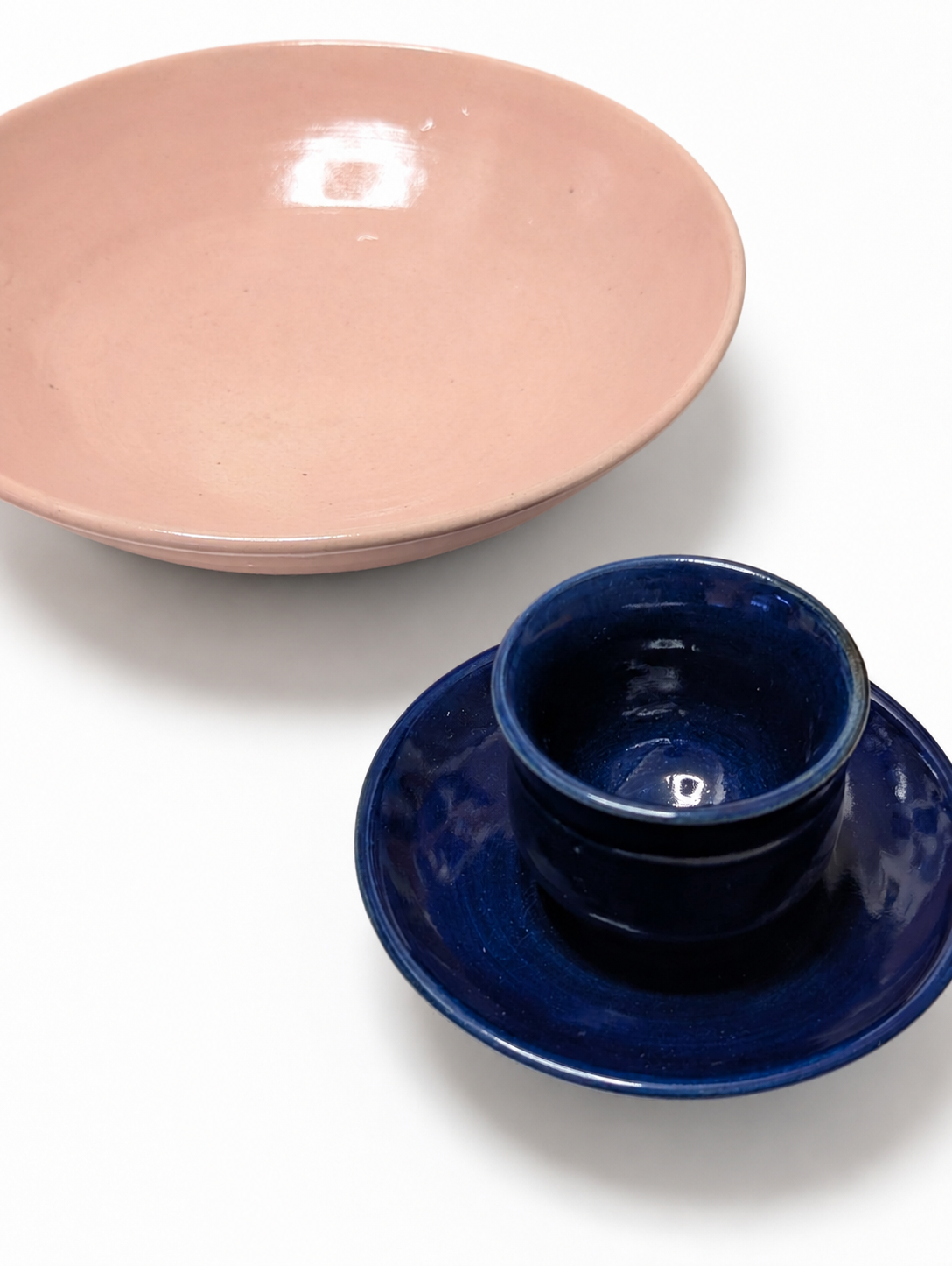 白背景に並んだピンクの皿と紺色のカップ