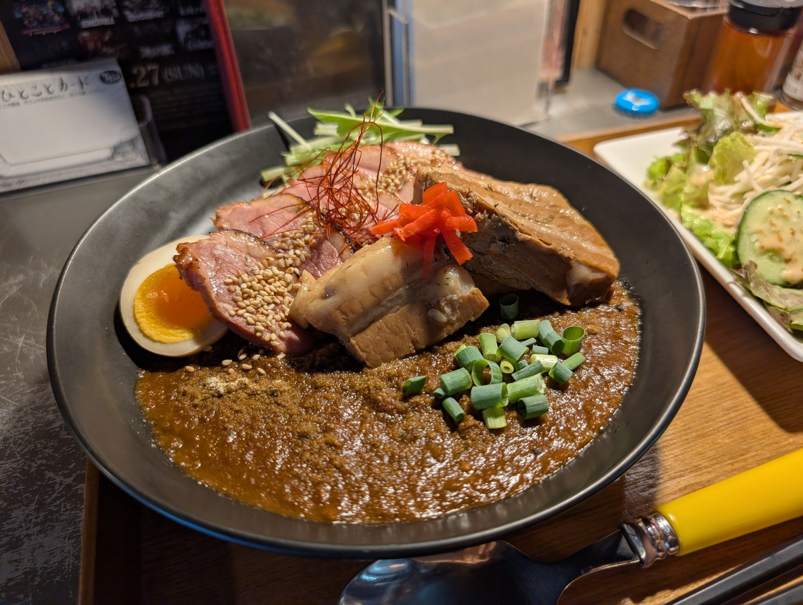 YASSカレーのスパイスカレー。合鴨ロースと角煮、味玉、紅生姜がのっている