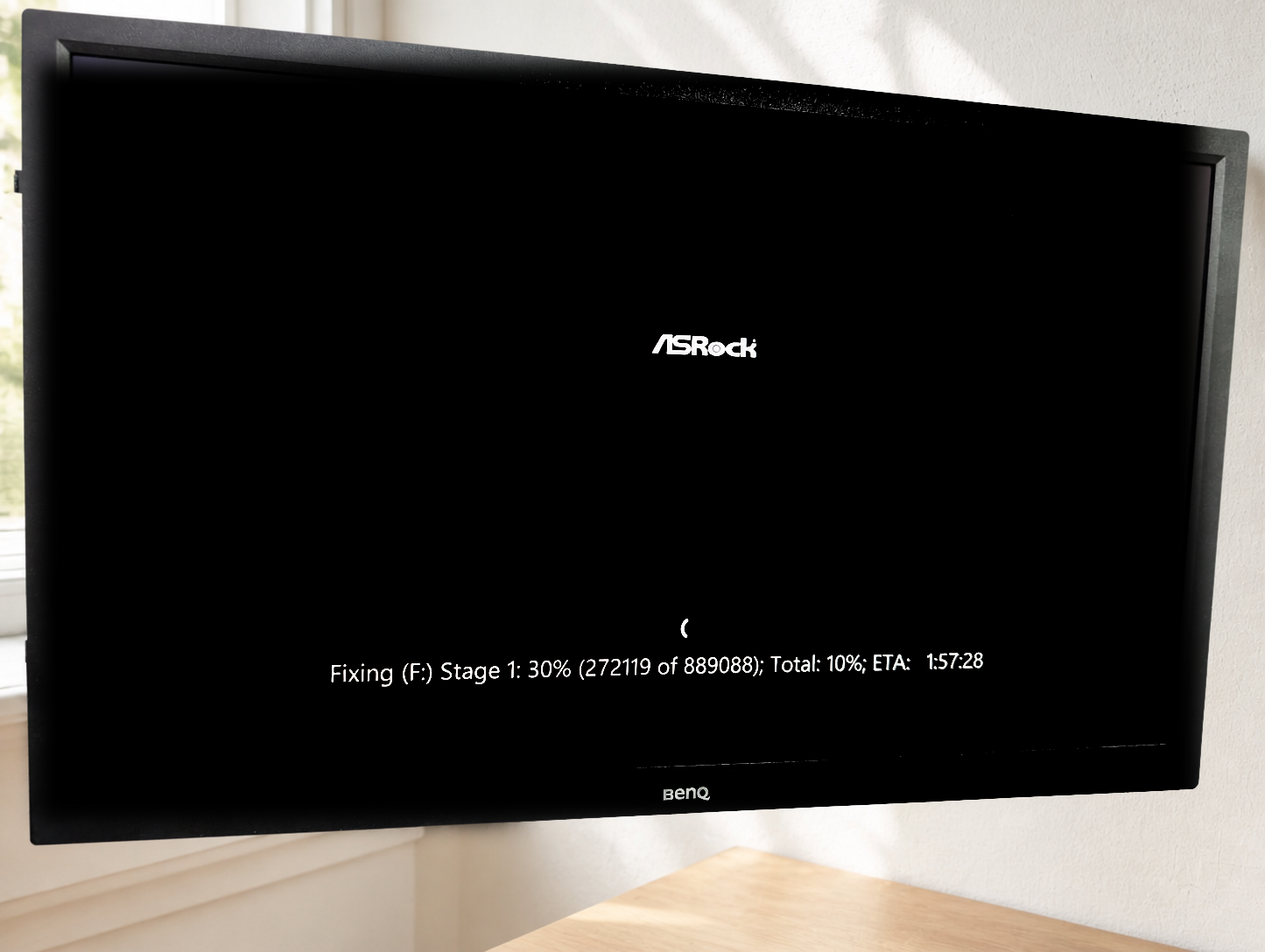 BenQのモニターに映ったディスク修復画面。ASRockのロゴの下にFixing (F:) Stage 1: 30%、ETA 1:57:28の表示