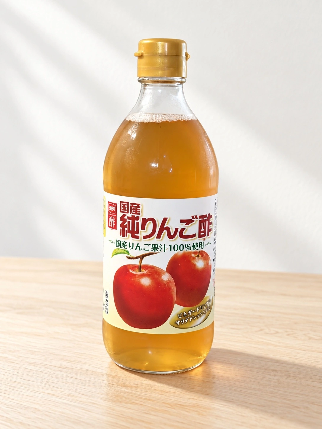 木の天板に立つ国産純りんご酢の瓶（背景はAIで差し替え）