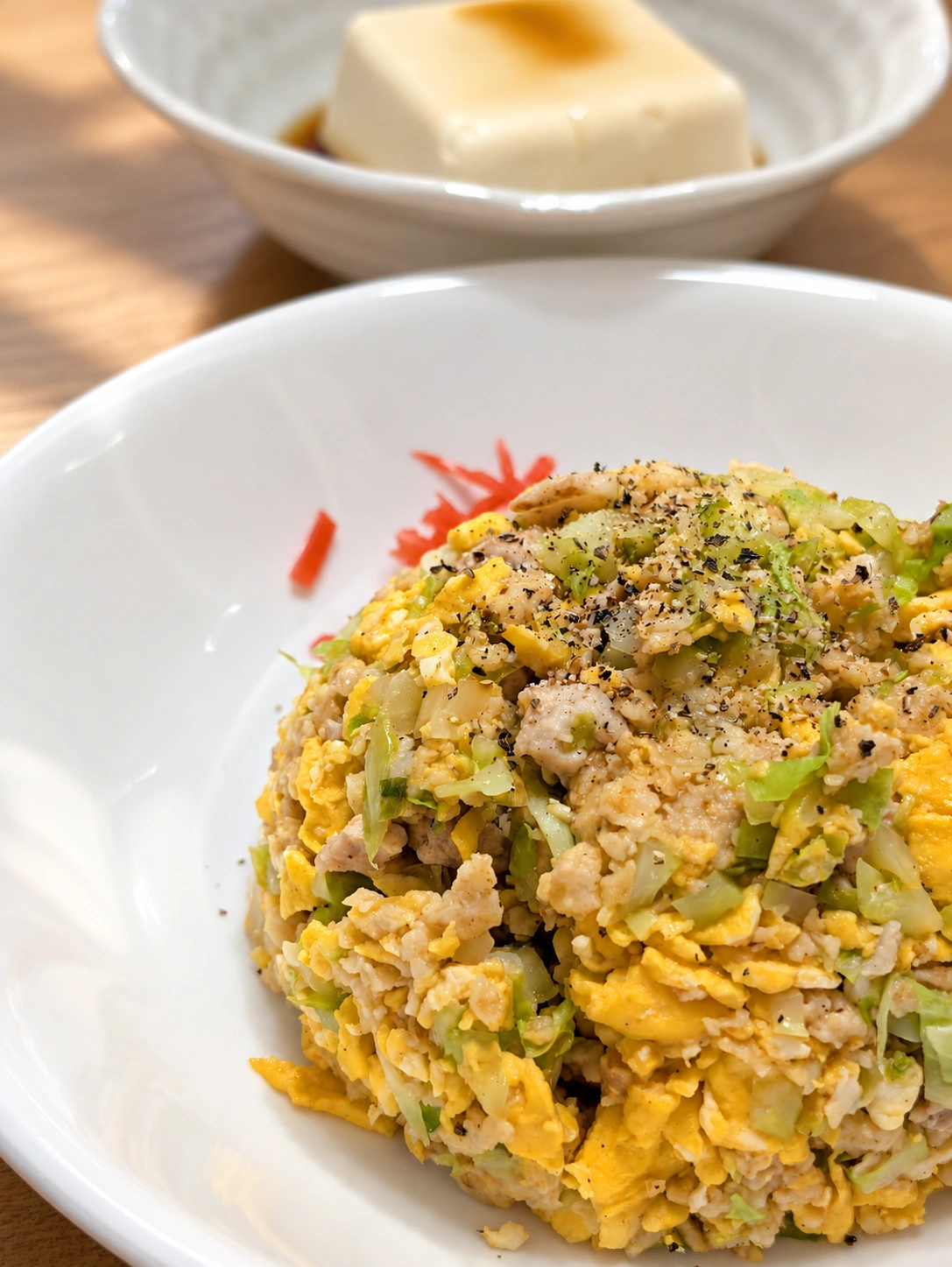 卵と野菜が入ったリュウジレシピのチャーハン（卓上などはAIで加工）