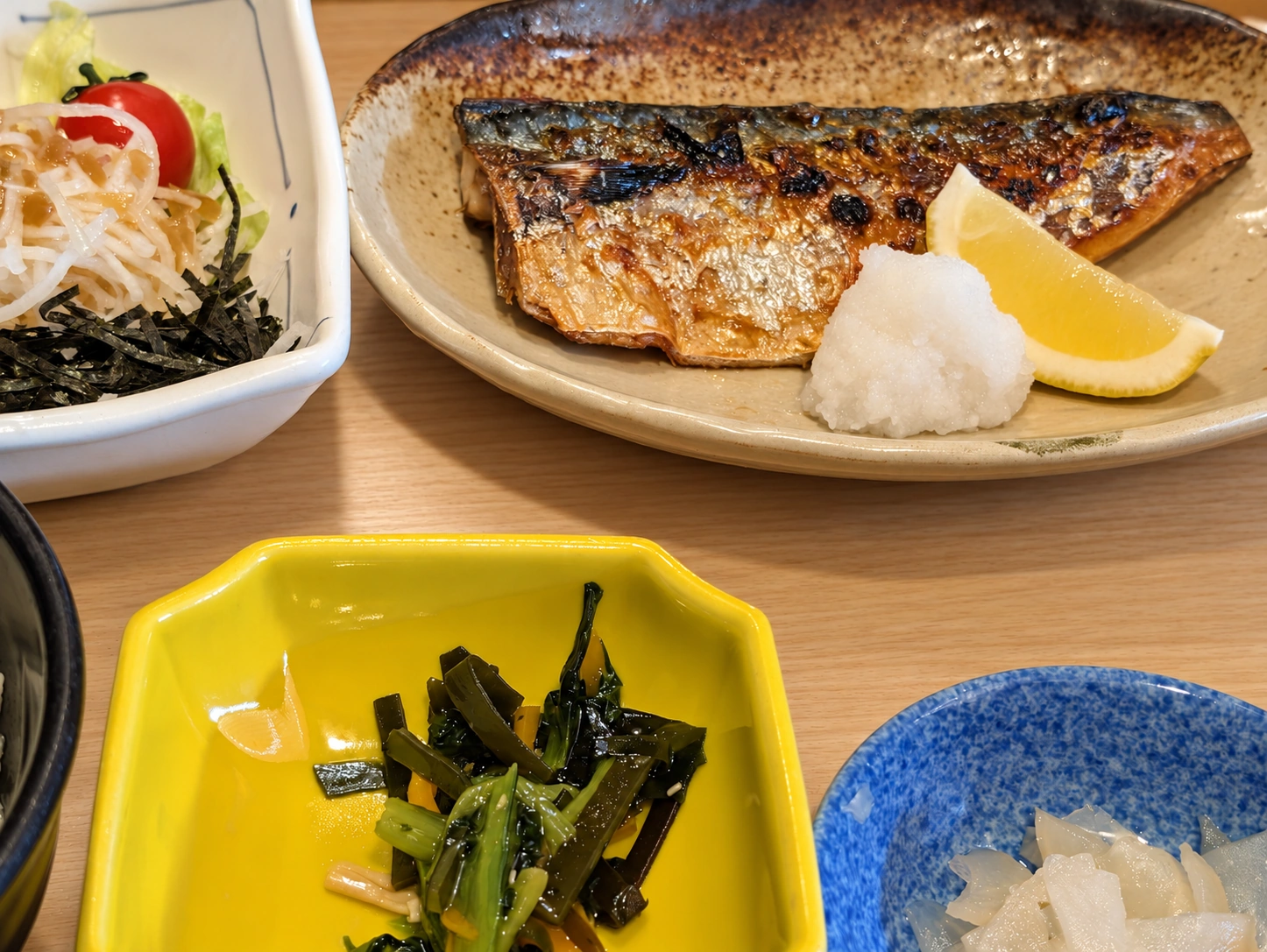 夢庵のランチ。鯖焼きに大根おろしとレモン、サラダと小鉢（卓上と明るさはAIで加工）