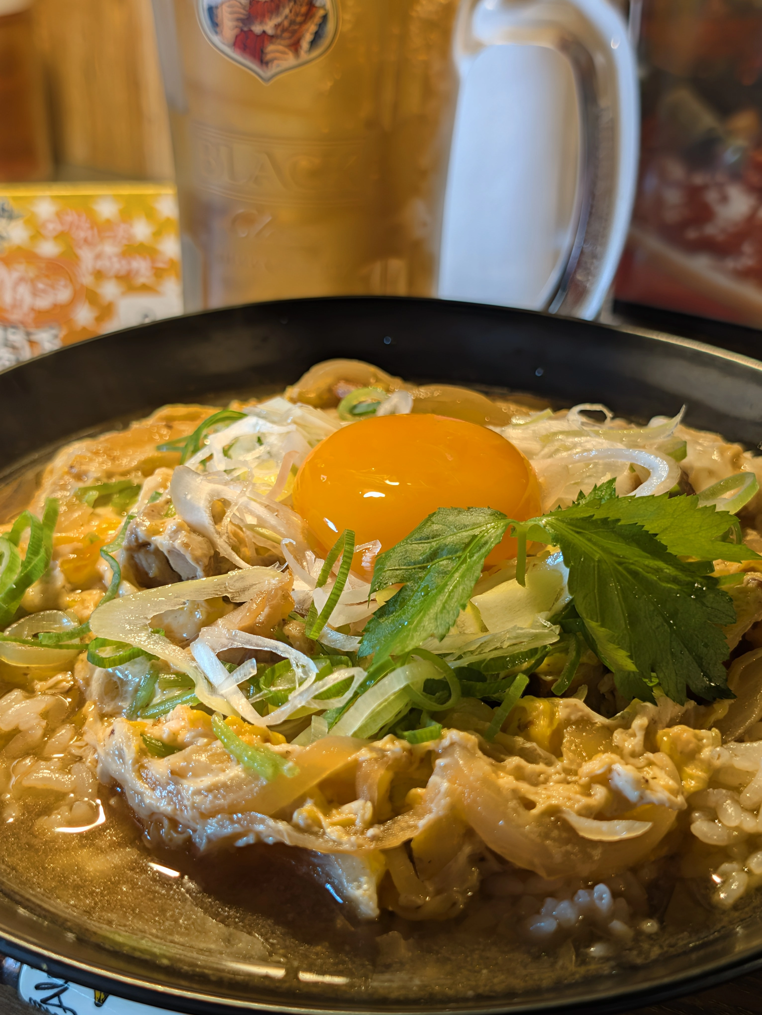 YASSカレーのモンスター・ペアレント。卵黄、チキン、ねぎが盛られた黒い皿